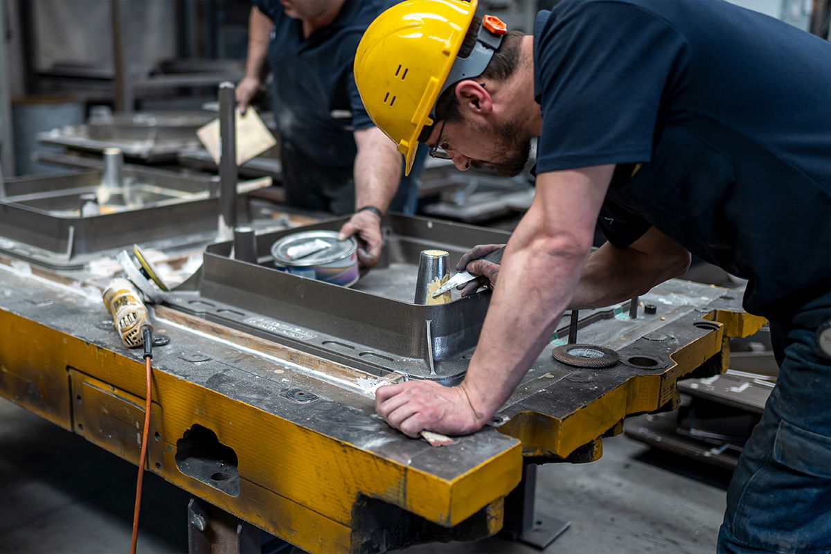 A skilled worker refining an iron product mould