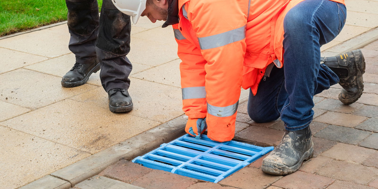 Man installing blue gully grating
