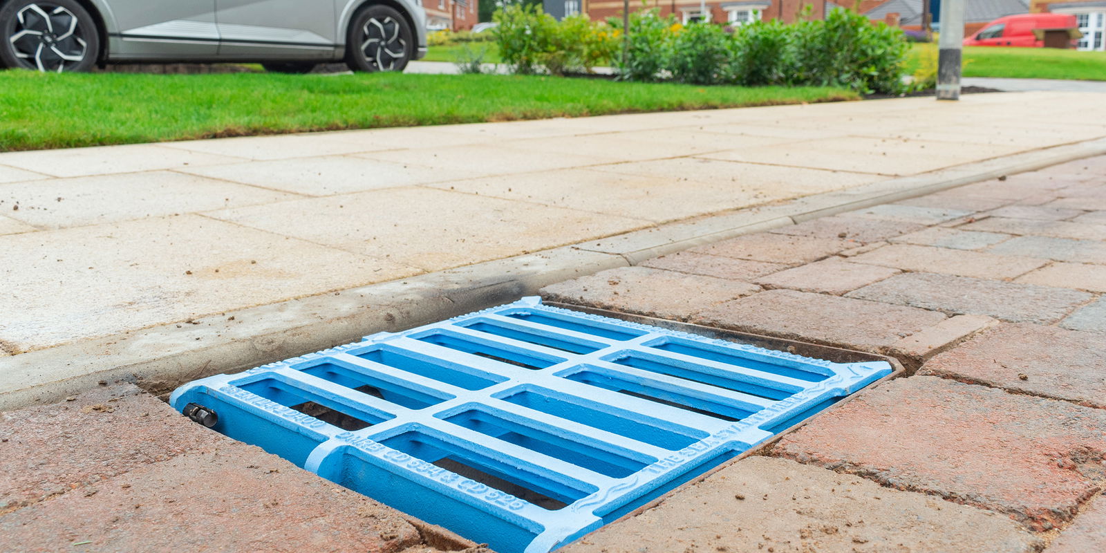 Blue gully grating installed in road