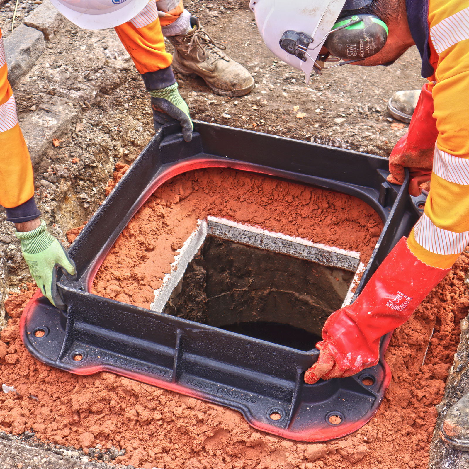 Unite manhole cover frame being installed by two workers