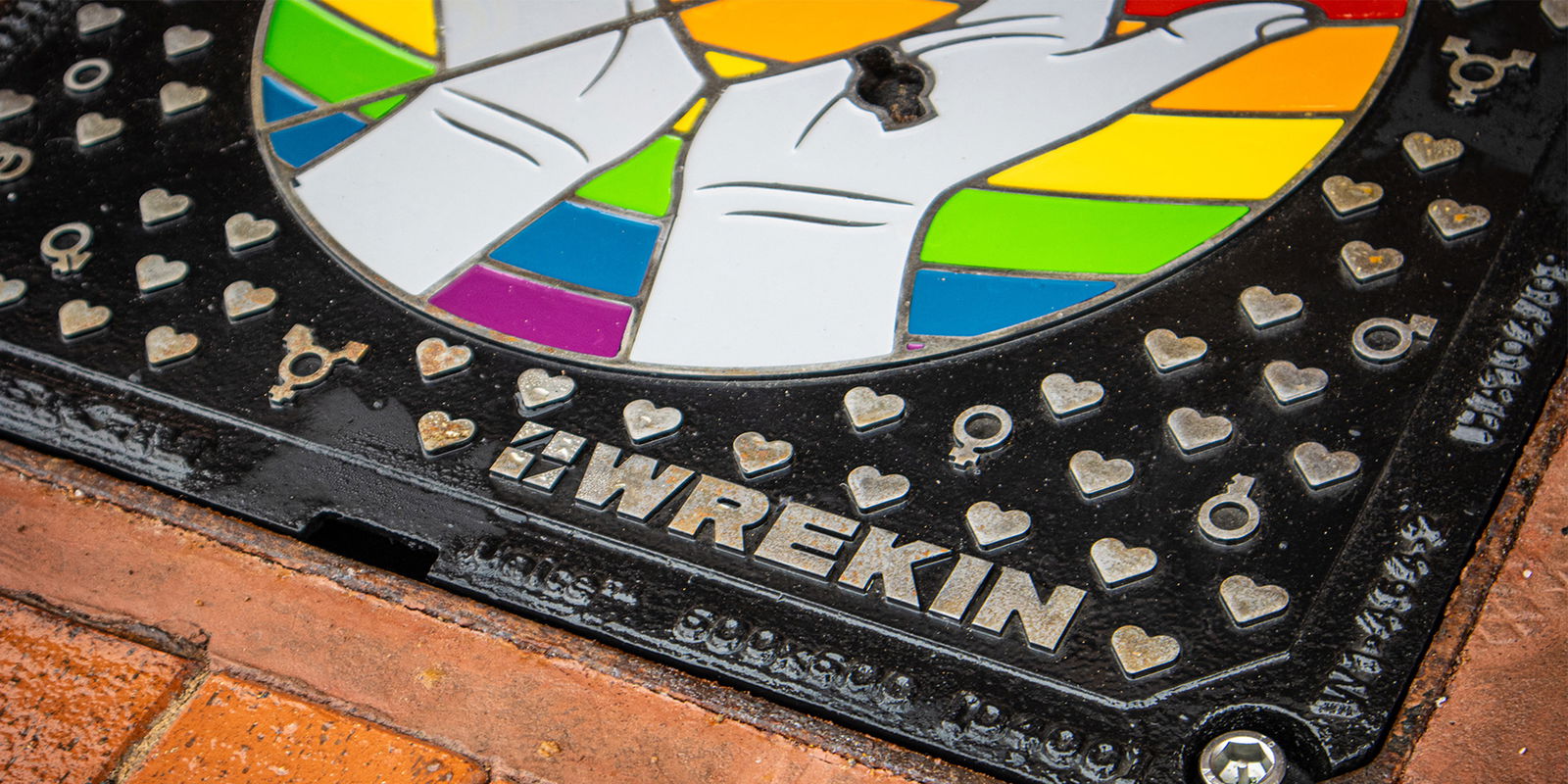 Wrekin bespoke LGBT manhole cover in block paved area