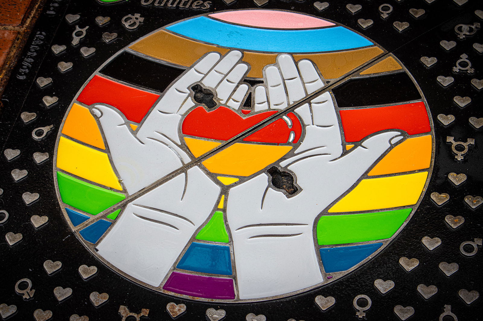 A heart held in hands as a chequer pattern on a bespoke Wrekin manhole cover