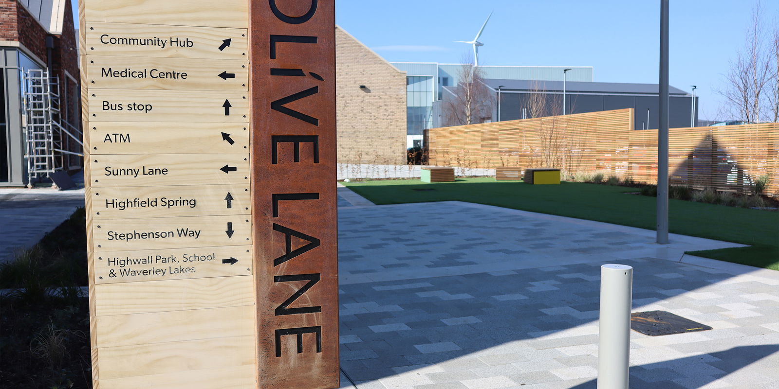 Olive Lane bespoke manhole cover installed next to sign