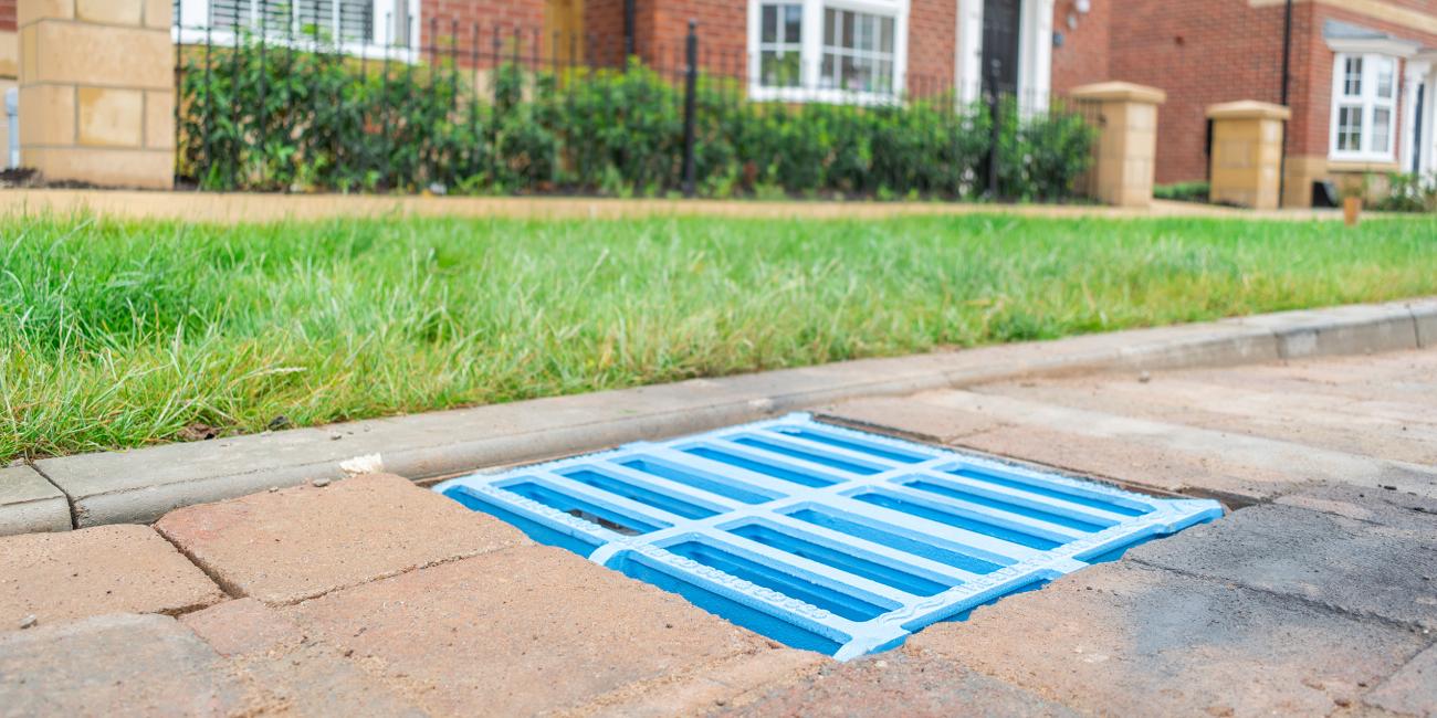 Blue gully grating installed in road