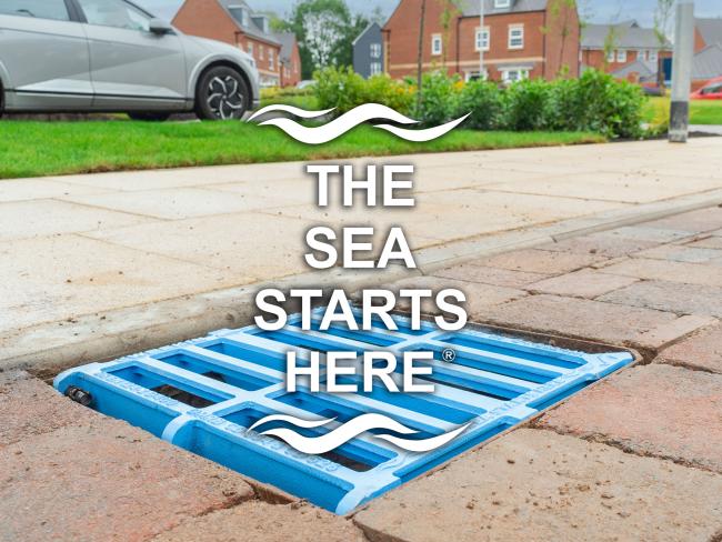 Blue Tristar gully grating installed in a block paved road