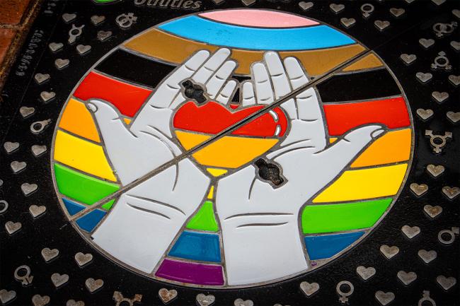 United Utilities Wrekin bespoke manhole cover showing rainbow colours and a heart held in hands